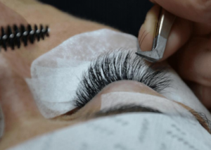 OJO DE MUJER CON PARCHES DE COLÁGENO PARA OJOS. PINZAS Y CEPILLO DE PESTAÑAS PARA COLOCAR EXTENSIÓN 3D