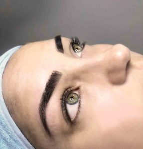 cara de mujer ojos azules y micronblading de cejas